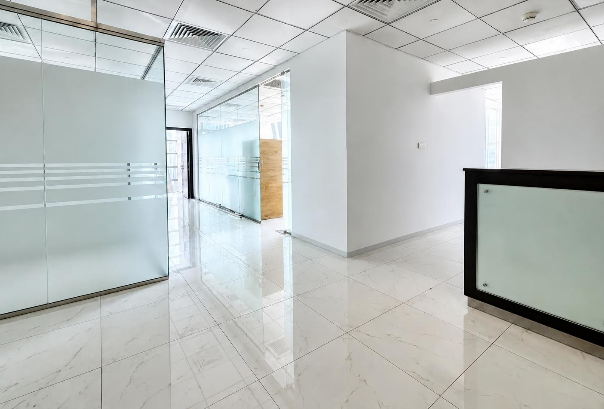 The Prism Business Bay office corridor with glass partitions